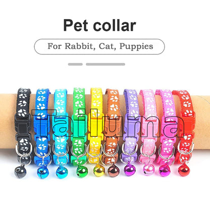 Multiple colorful pet collars with bells displayed on a hand. These adjustable collars are paw designed for rabbits, cats, and puppies.