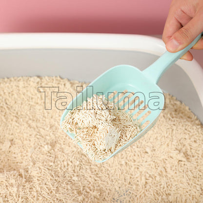 A hand using a plastic scoop to lift cat litter from a litter box.