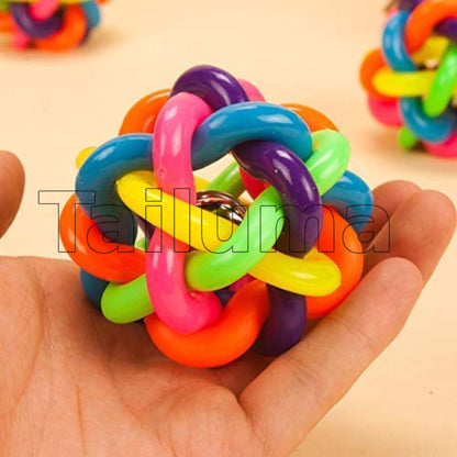 Multicolor rubber dog toy ball being held in a hand,small metal bell inside.