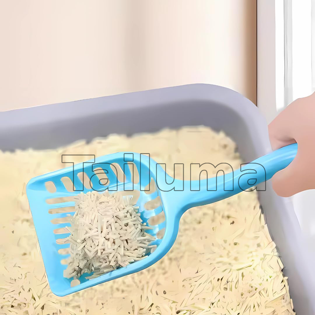 A hand using a blue scoop to clean cat litter from a litter box.